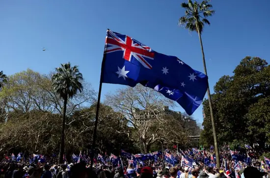 Protesters raise Australian flag at an anti-immigration rally in Sydney, Aug 31, 2025.
