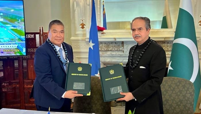 "Pakistan and Micronesia ambassadors exchanging documents to formalize diplomatic relations at the UN in New York.