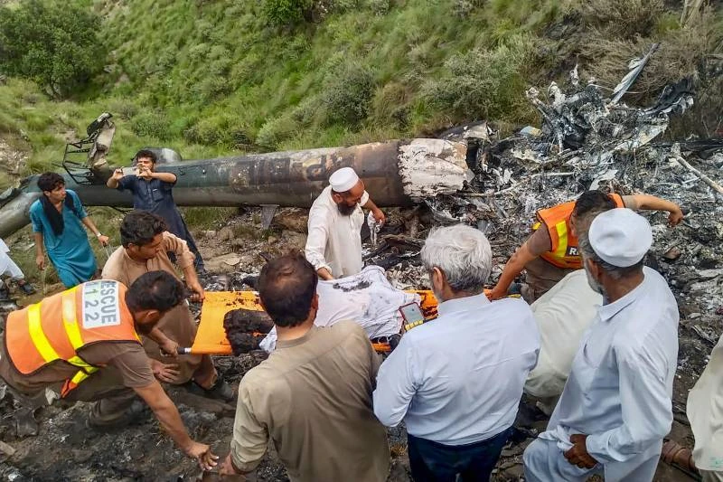 Residents and rescue staffers surveying damage from landslides and flash floods in KP.