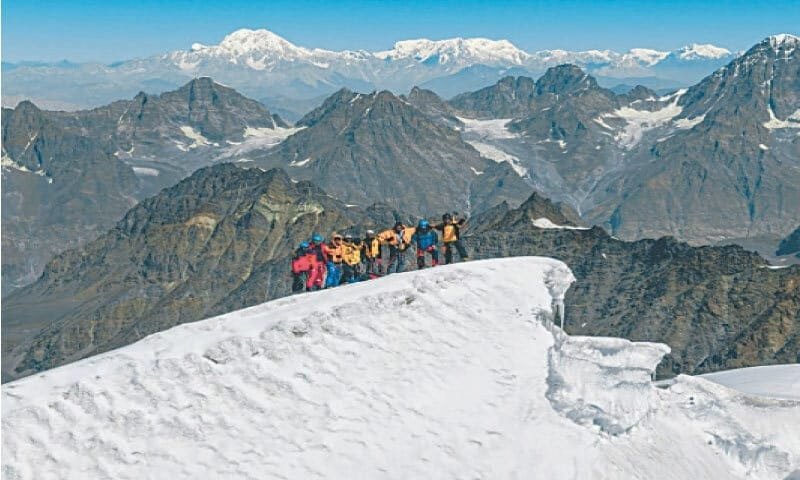 Nine members of the Chitral-based Shabdaraz mountaineering team stand on the snowy summit of Thalo Zom (6,050m) in the Hindu Raj range located in Chitral.