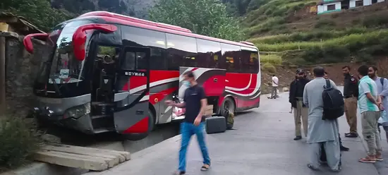 Passengers look at a Marvi bus that met with an accident after crossing two tunnels on Lowari on way to Chitral from Islamabad, Sept 6, 2025.