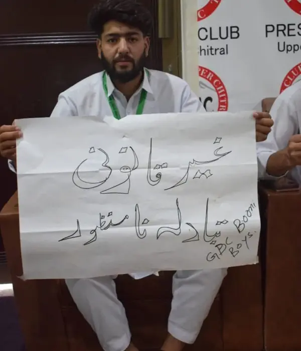 A GDC Booni student holds a placard inscribed with slogan of illegal transfer of principal and lecturer unacceptable.