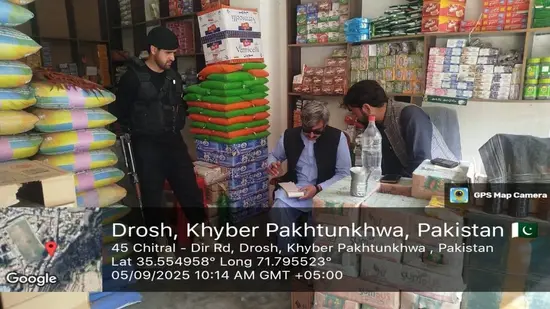 Assistant Commissioner Drosh Muhammad Ali checks a shop during an inspection of Drosh Bazar.