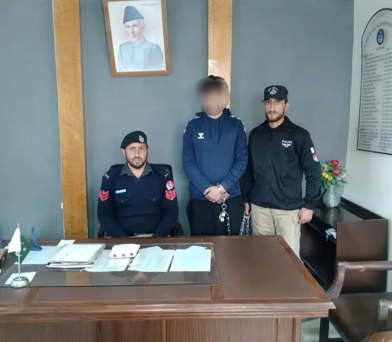 Chitral police officials pictured with a young man after his arrest with charas.