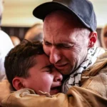 A Palestinian man hugs his son after being released from Israeli prison under Gaza peace agreement, Oct 13, 2025.