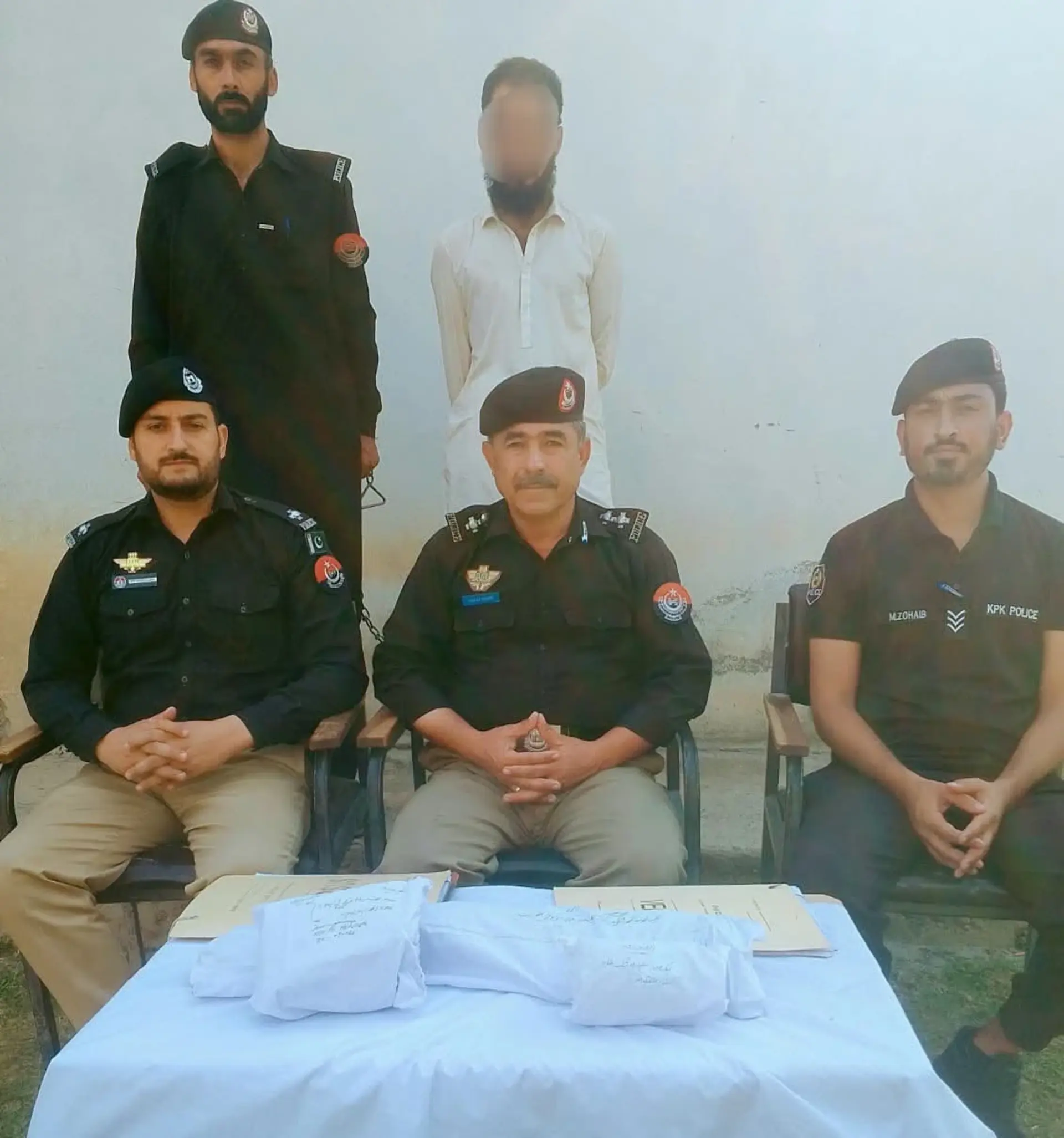 Police officials of Drosh pictured with a man belonging to Dir after his arrest at ashiret after recovery of a rifle from him.