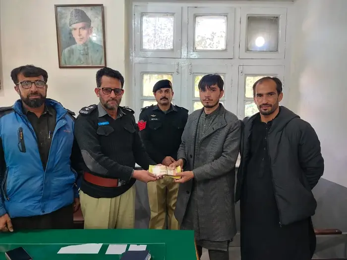 Lost cash being handed to owner after recovery thru CCTV footage by Chitral police.