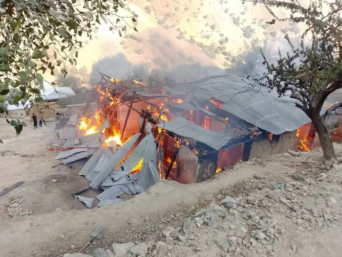 District administration officials provide relief items to a family whose house was gutted in fire in Damil Nisar.