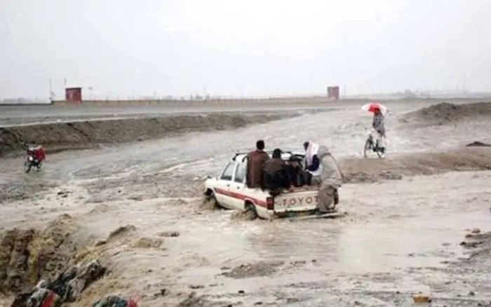A vehicle carrying people is trying to cross a flooded stream in KP, July 2026.