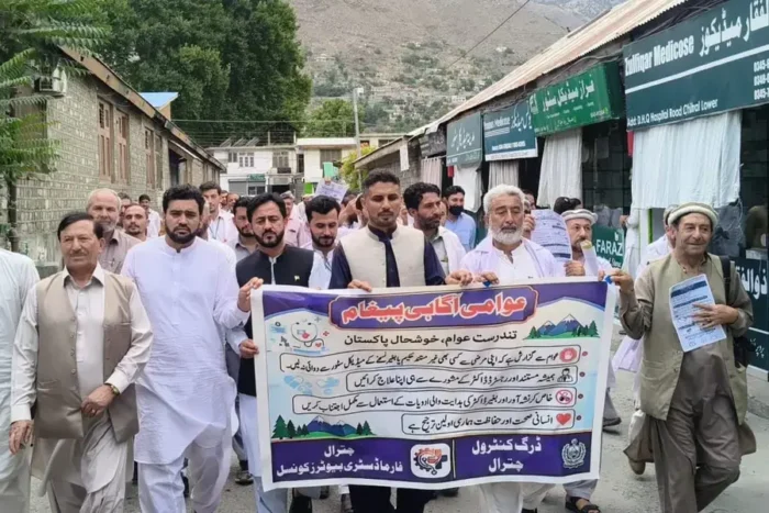 Participants of a walk in Chitral carry a banners against misuse of controlled drugs.