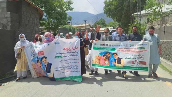 Participants carry banners during a walk held to create awareness about importance of breastfeeding in Chitral.